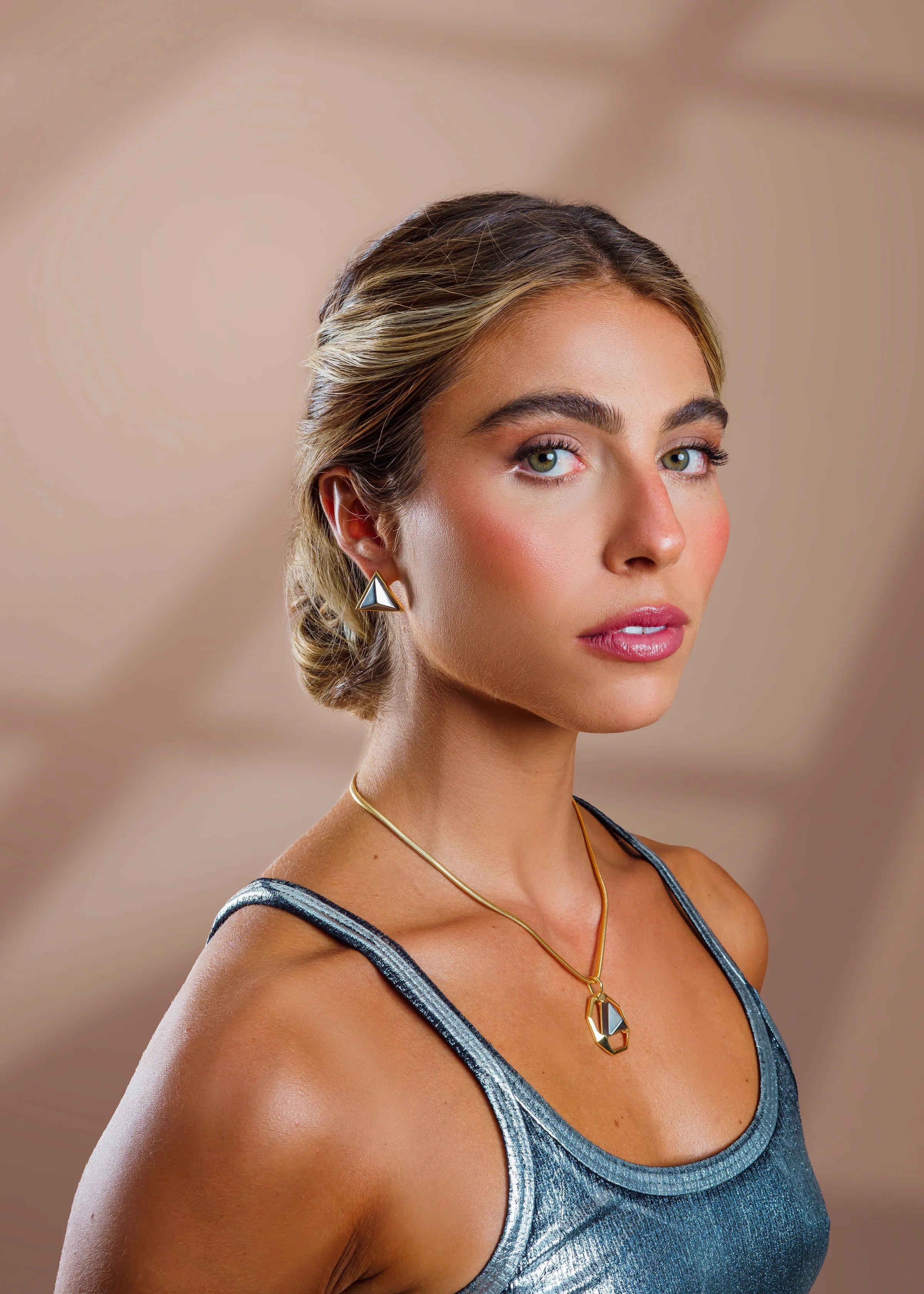 Woman wearing a blue tank top with a neutral background