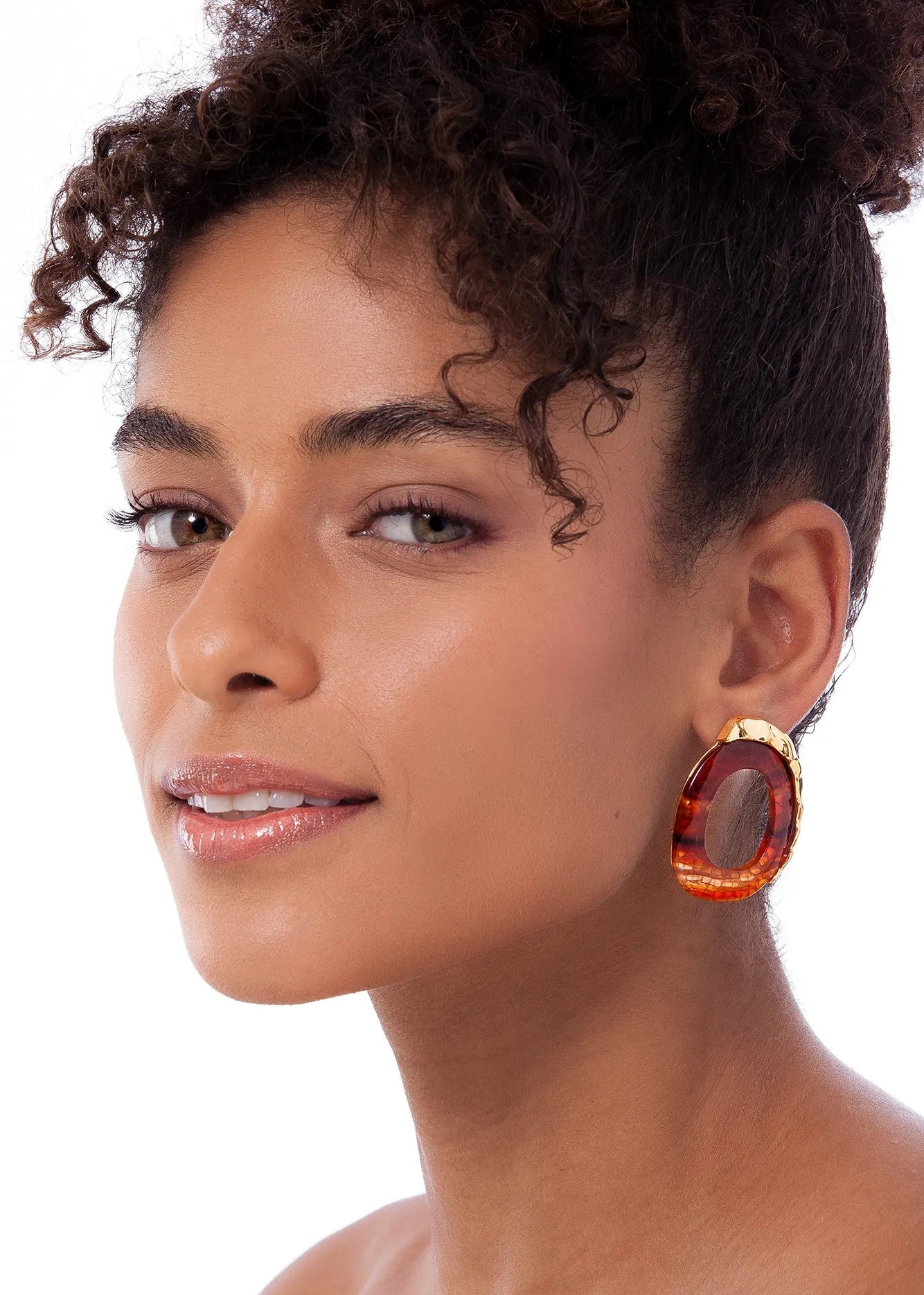 Woman wearing large hoop earrings on a white background