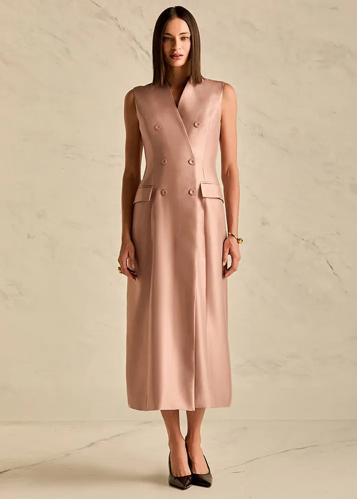 Woman wearing a sleeveless pink dress against a beige background