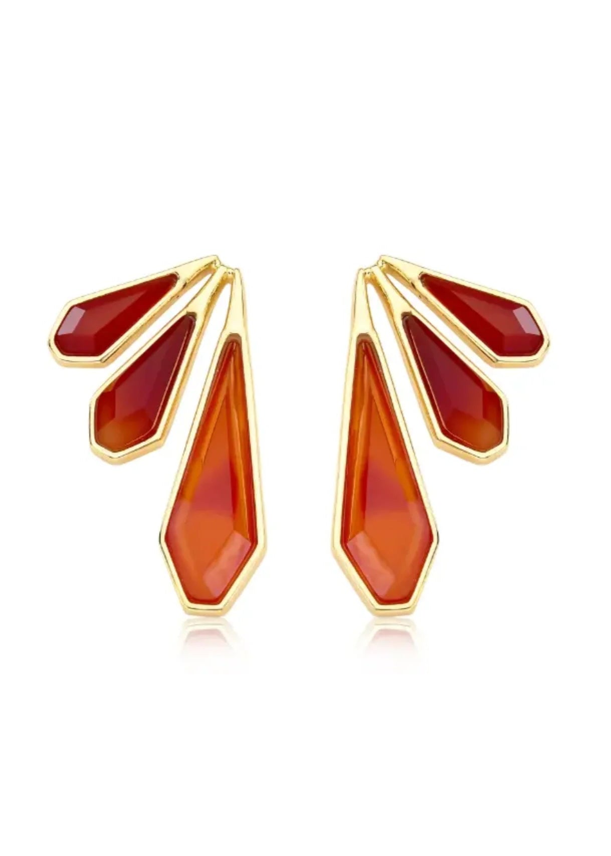 Gold and red earrings on a white background