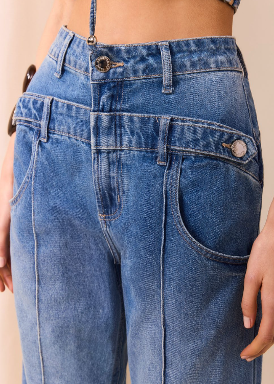 Blue jeans worn by a person on a beige background