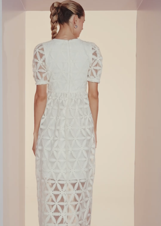 Woman wearing a light blue lace dress in a minimal white room