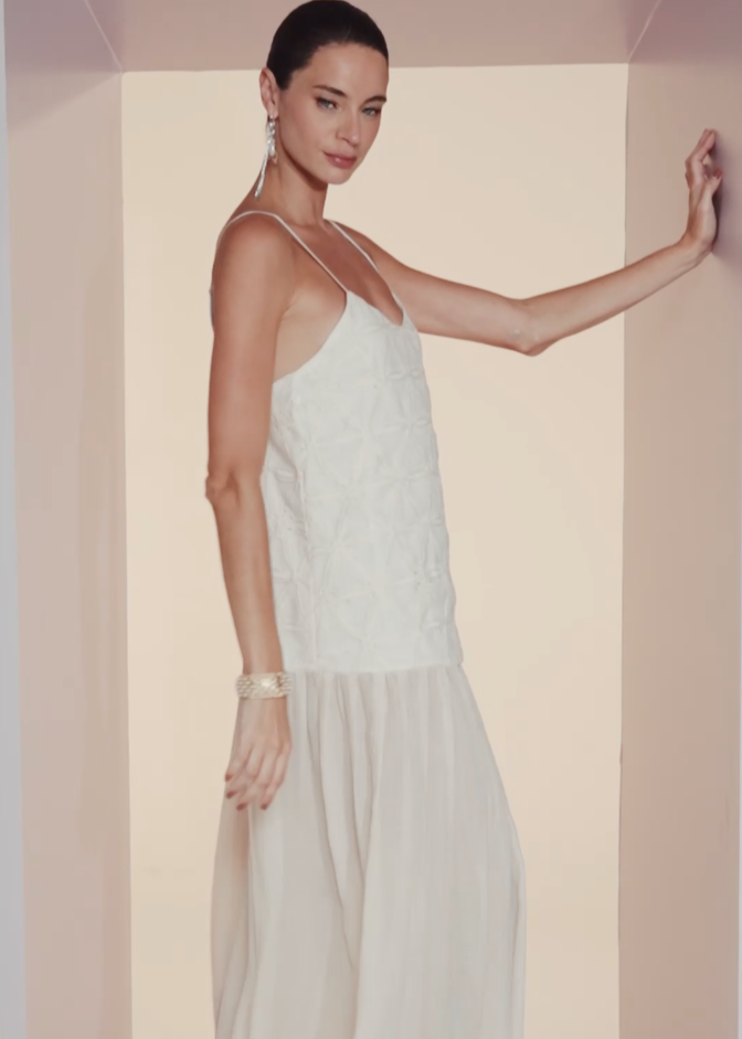 Woman wearing a white dress against a plain background