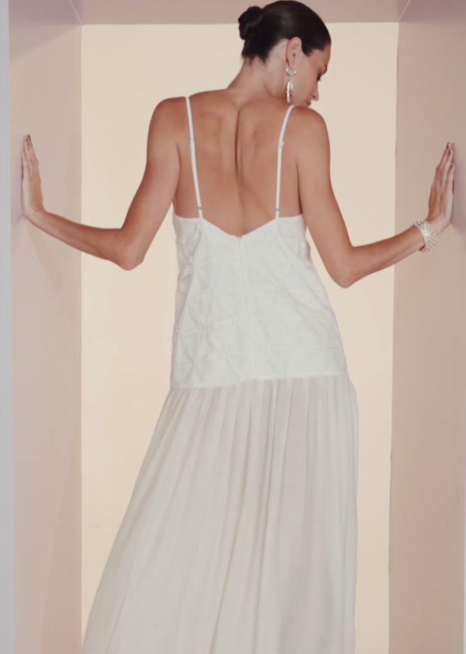 Woman wearing a white dress with thin straps in a minimal setting