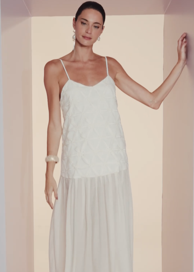 Woman wearing a white dress against a plain background