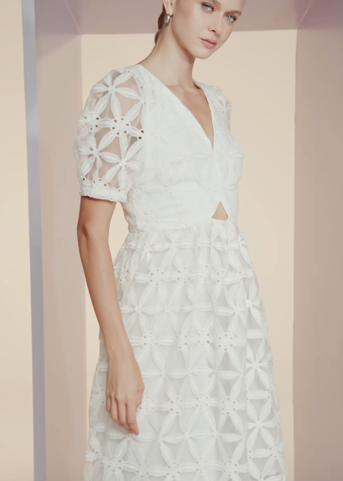 White lace dress with geometric patterns on a neutral background
