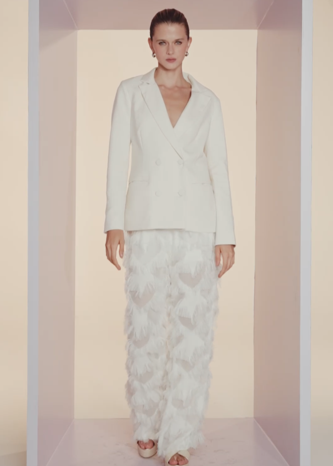 Woman wearing a white outfit with a floral pattern in a minimalistic setting