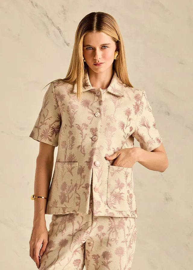 Woman wearing a floral pajama set against a beige background