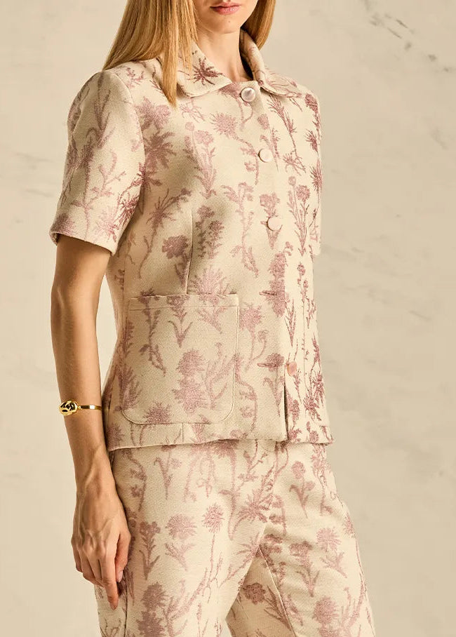 Woman wearing a floral pajama set against a neutral background