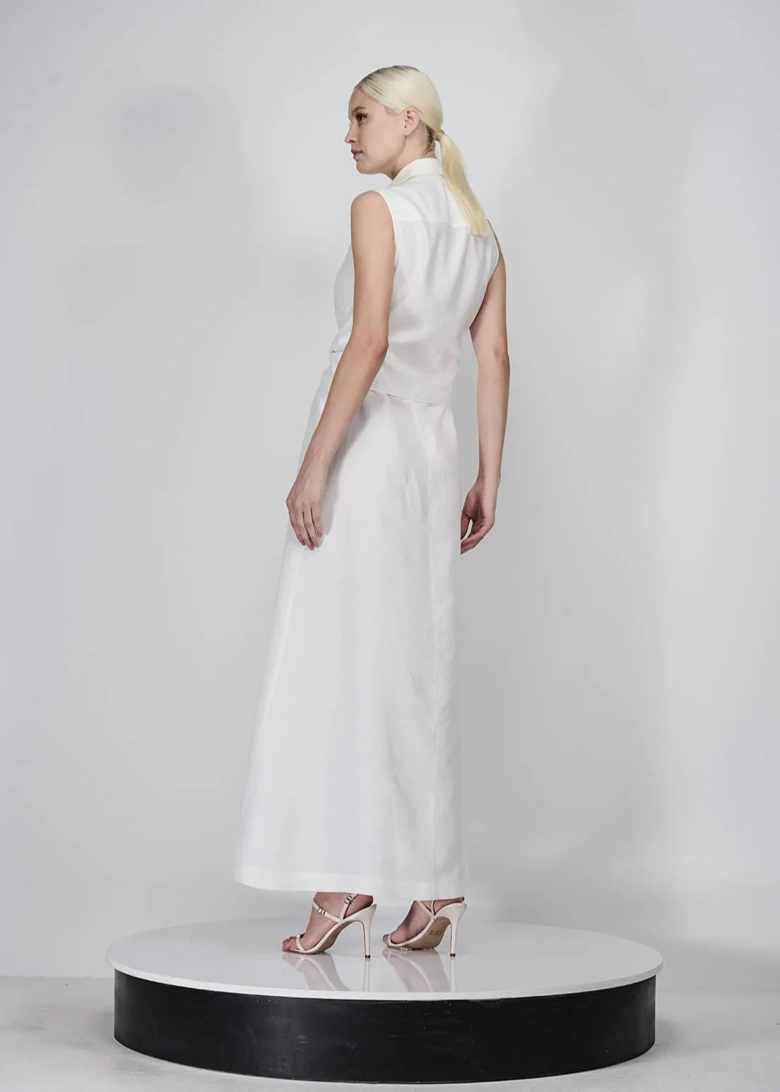 Woman in a white dress standing on a white background