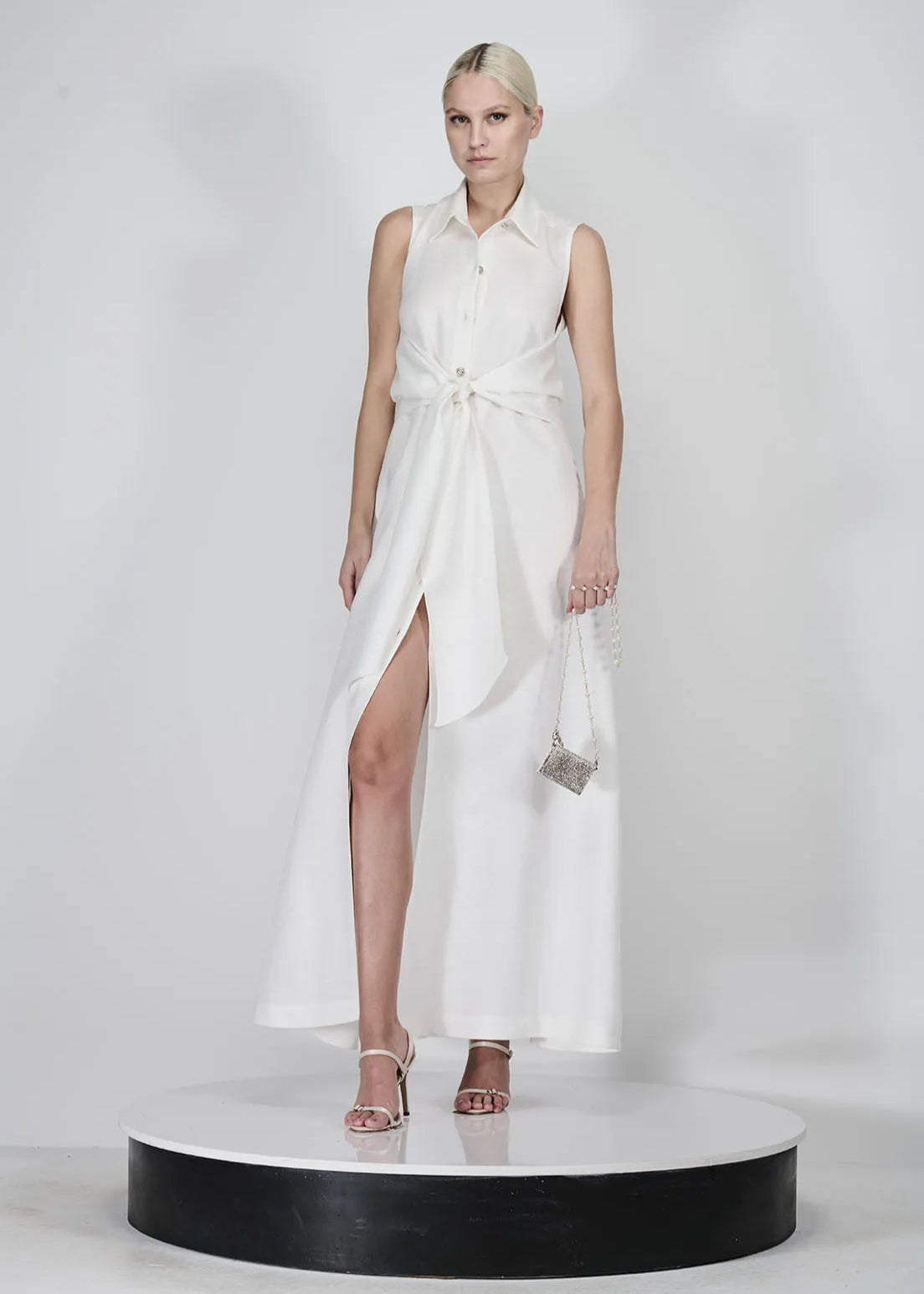 Model wearing a white sleeveless dress on a white background