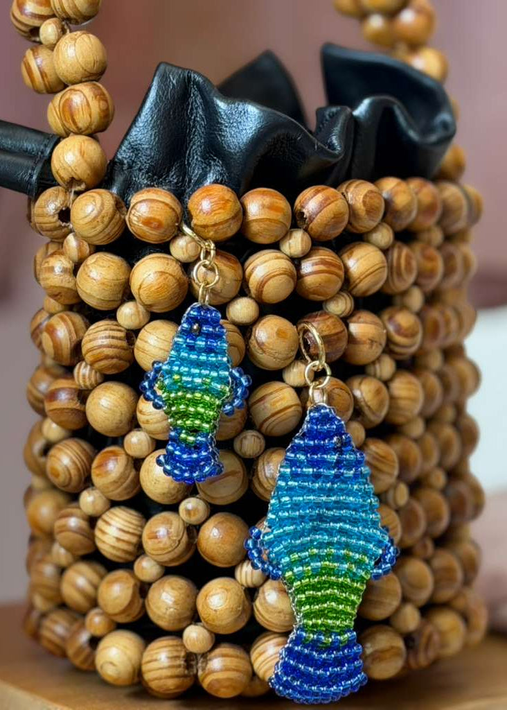 Blue and green beaded fish charms on a wooden bead bag