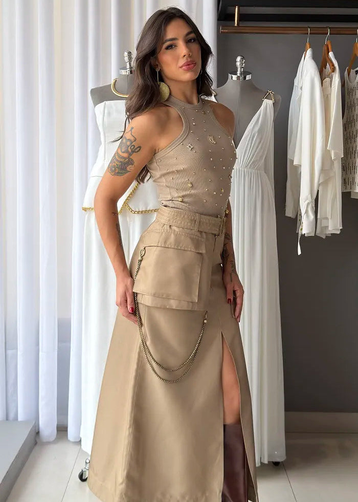 Woman wearing a beige dress with a slit and brown boots in a clothing store.