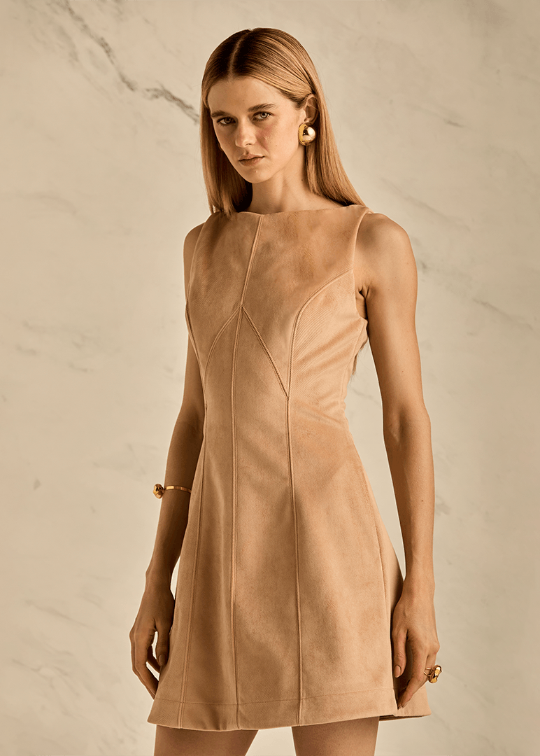 Woman wearing a beige dress against a neutral background