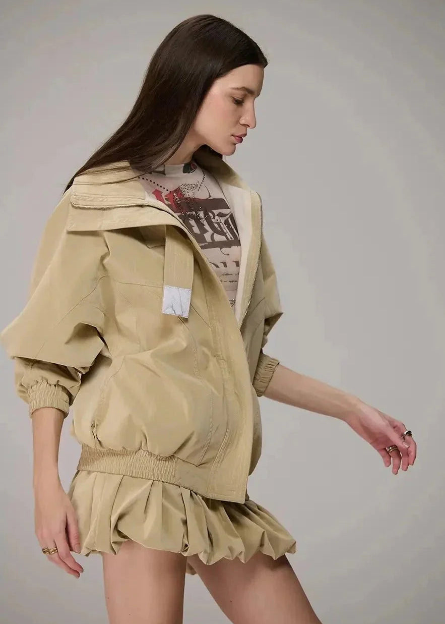 Woman wearing a beige jacket and skirt set on a plain background