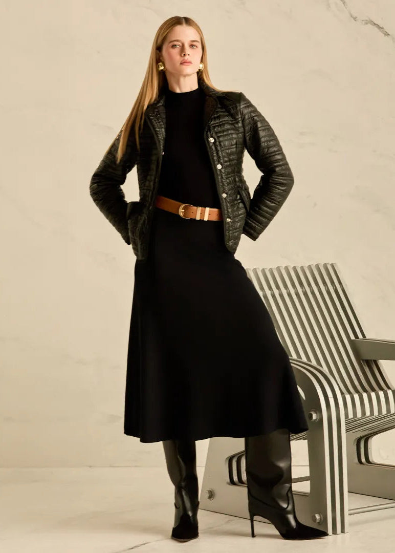 Woman in a black coat and long black skirt