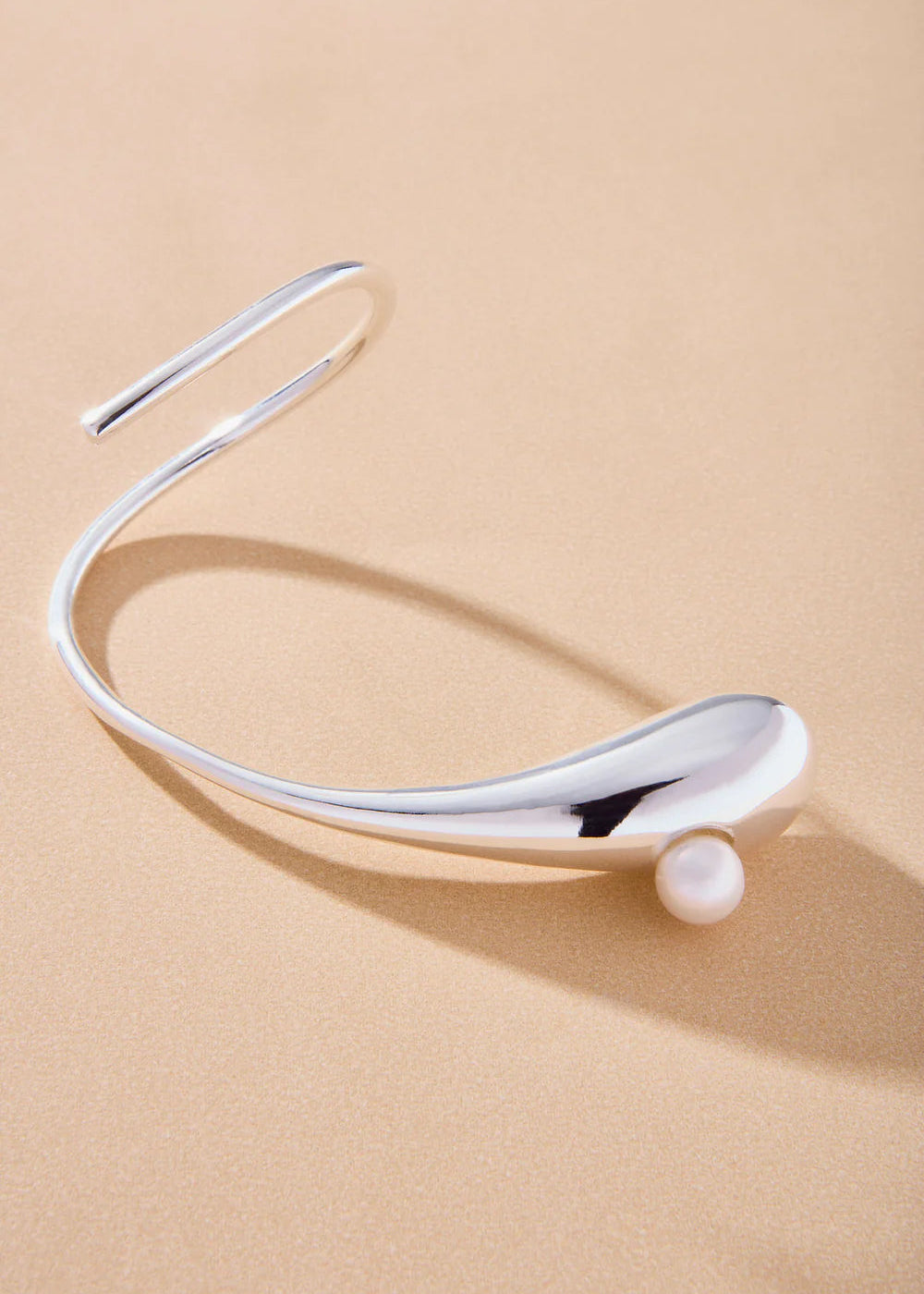 Silver headband with a pearl on a beige background