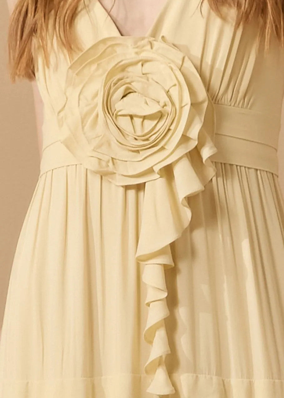 Beige dress with a large floral embellishment on a neutral background