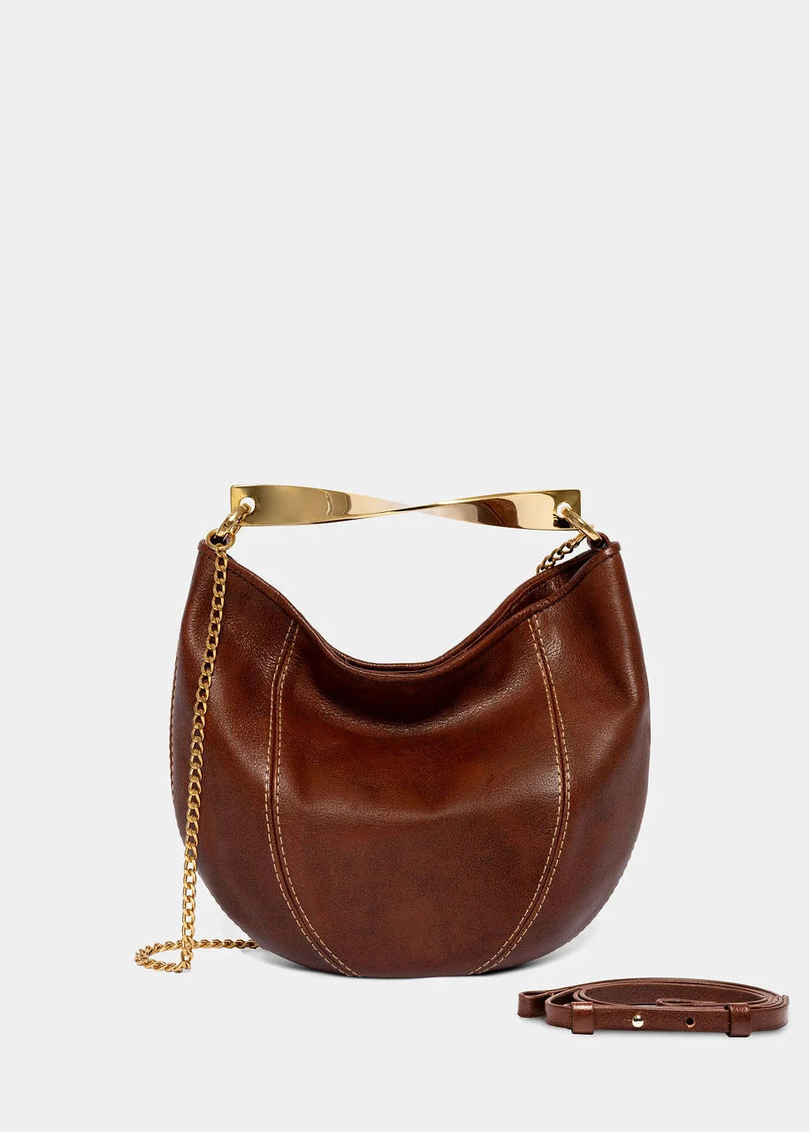 Brown leather handbag with gold chain and strap on a light gray background