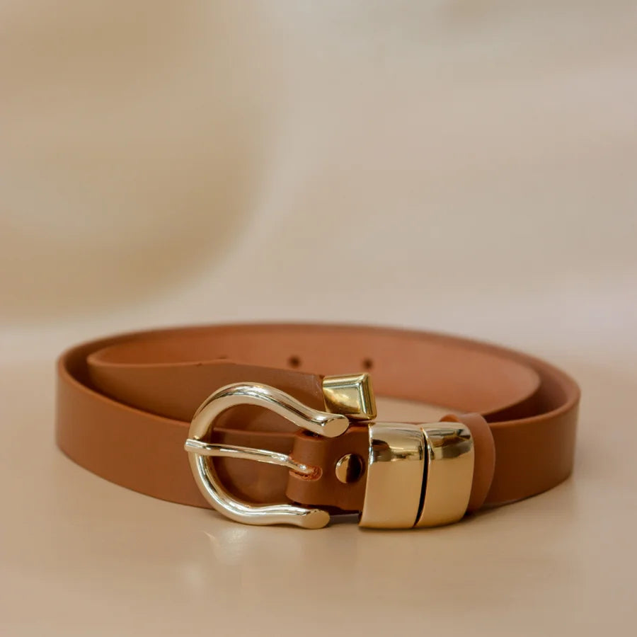 Brown belt with gold buckle on a beige background