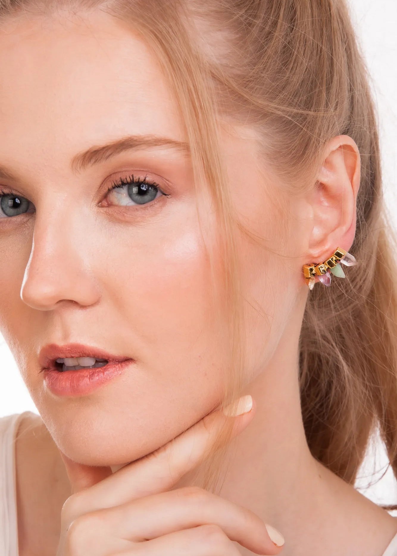 Close-up of a woman wearing earrings with a neutral background
