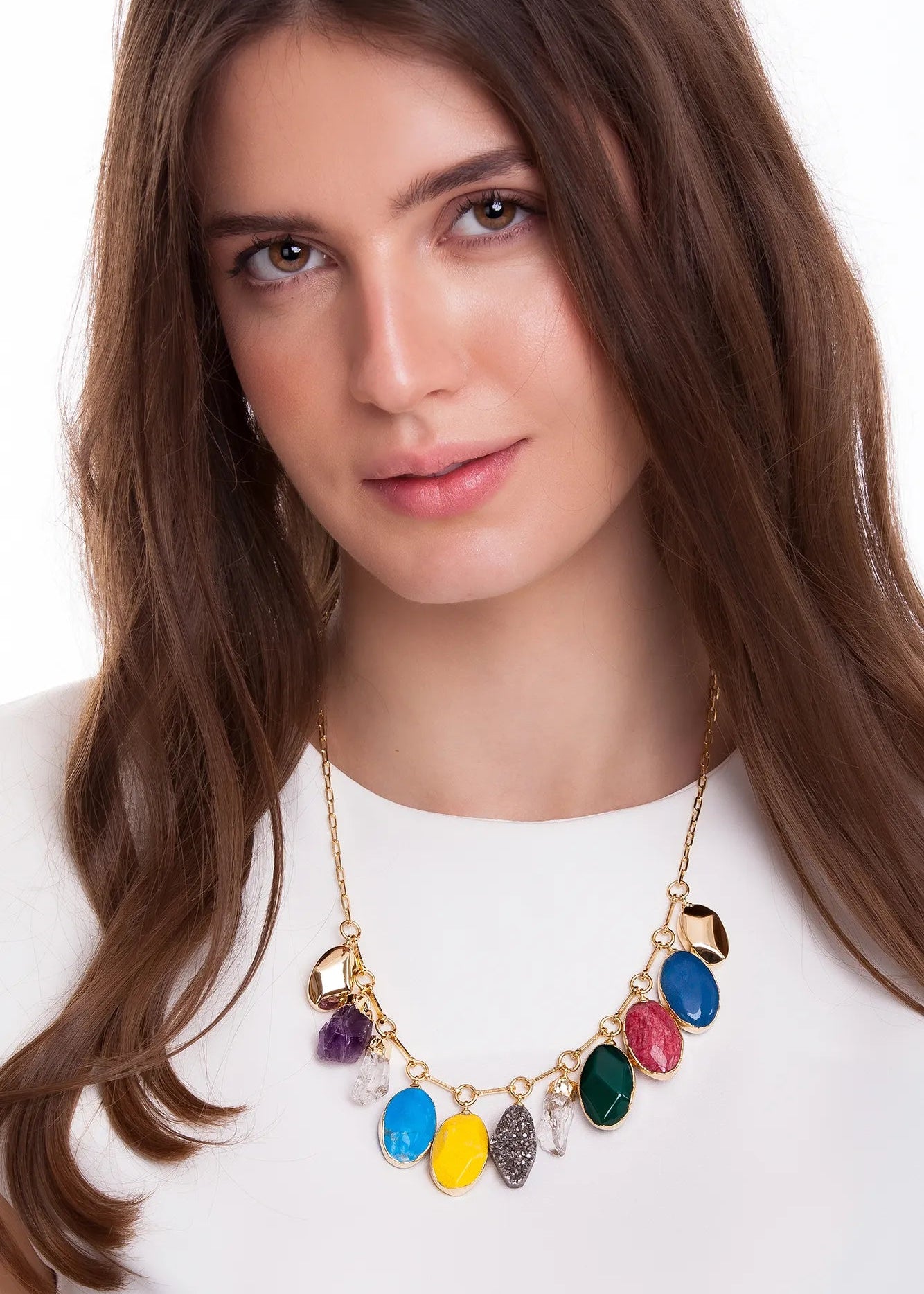 Woman wearing a colorful necklace with gemstones on a white background