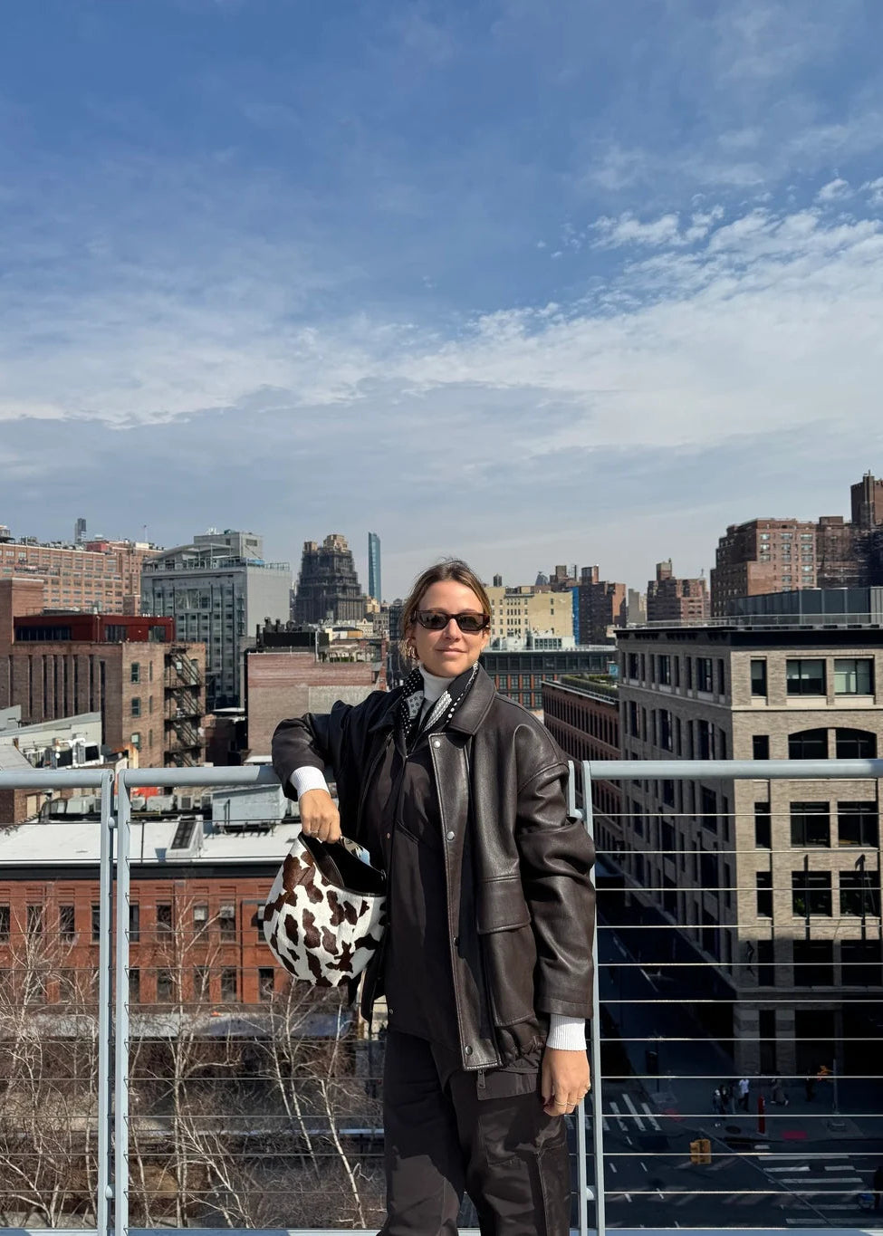 Person standing on a rooftop with a cityscape in the background