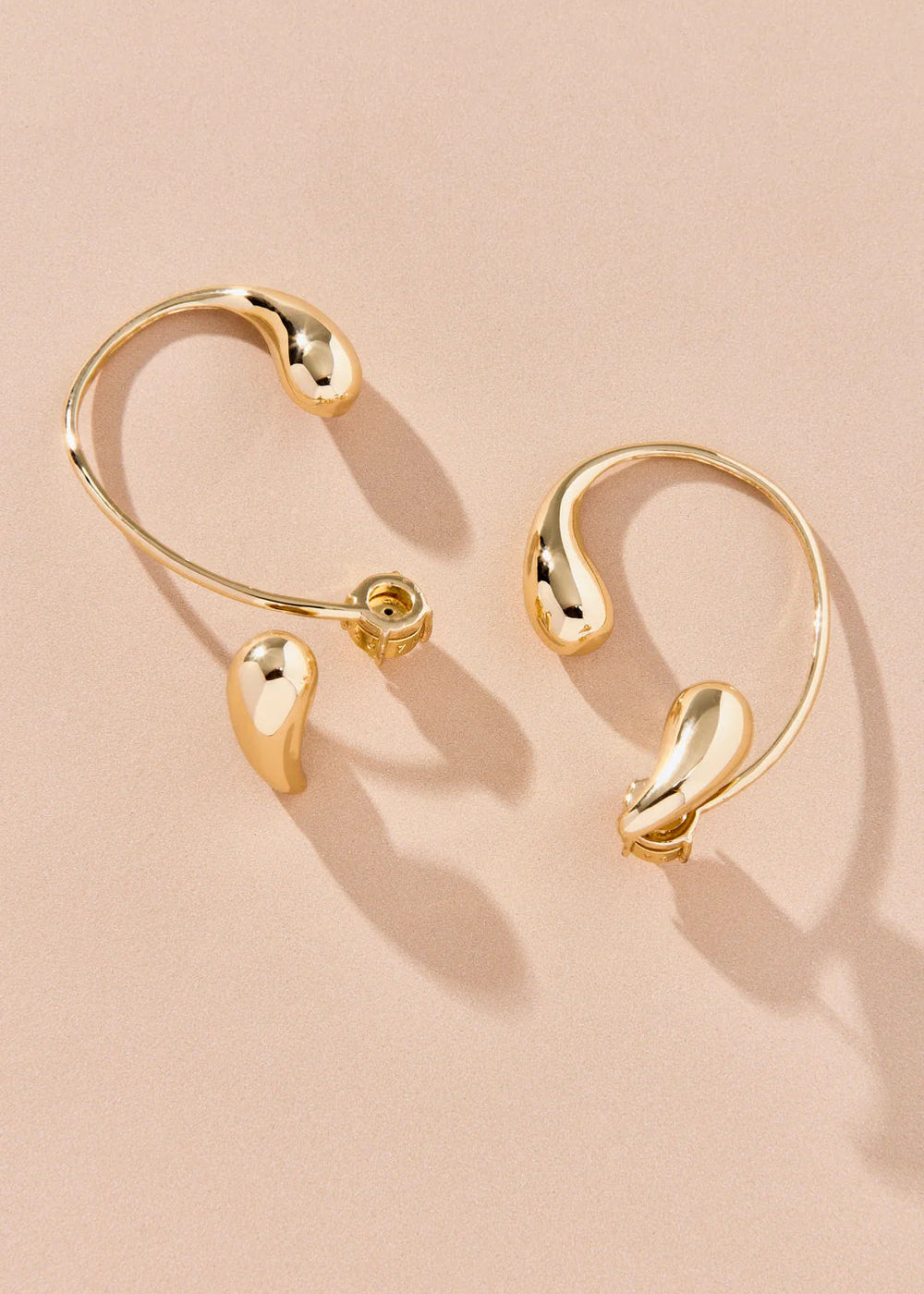 Gold hoop earrings on a beige background