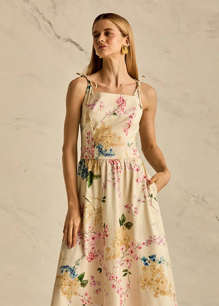 Woman wearing a floral dress against a neutral background