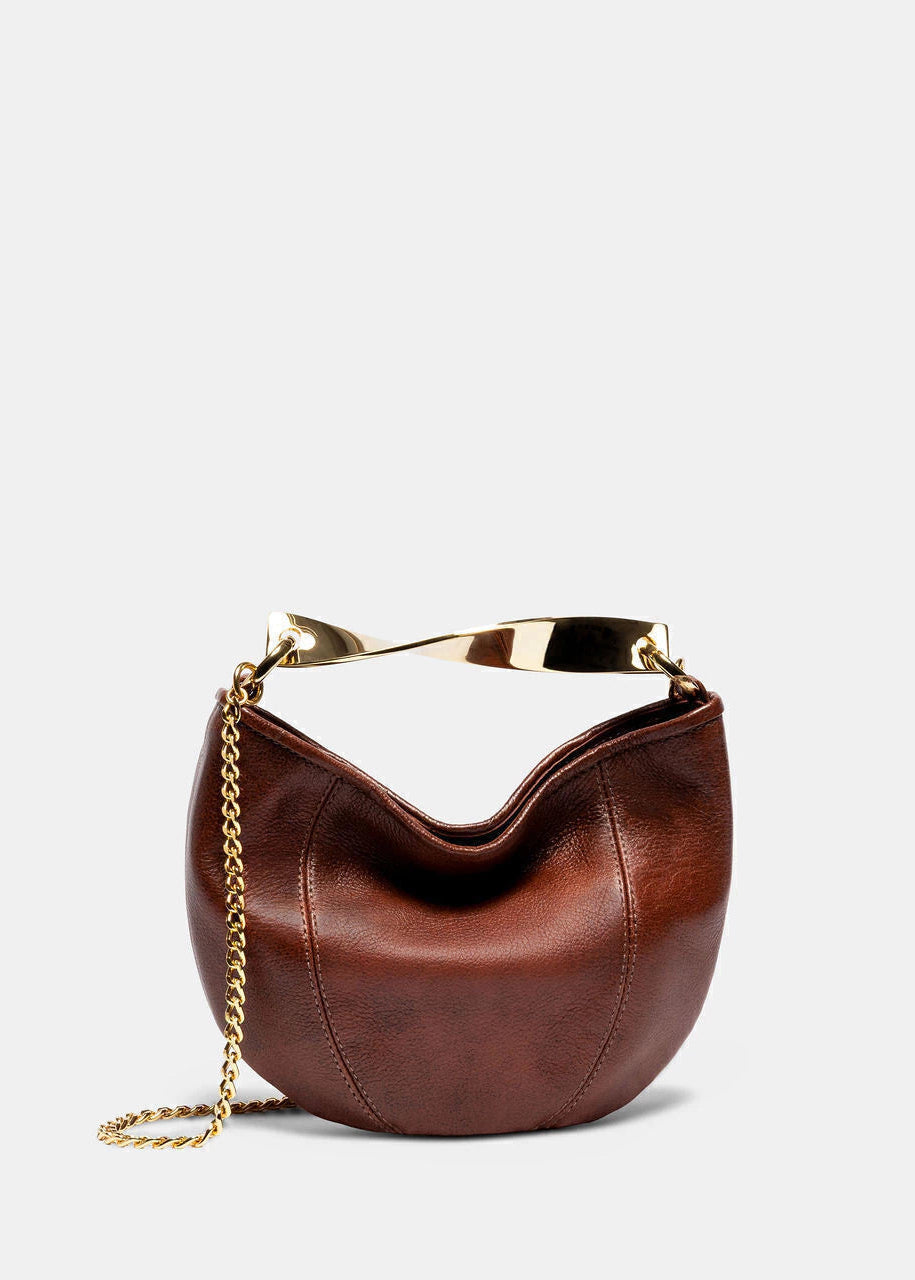 Brown leather handbag with gold chain and handle on a light gray background