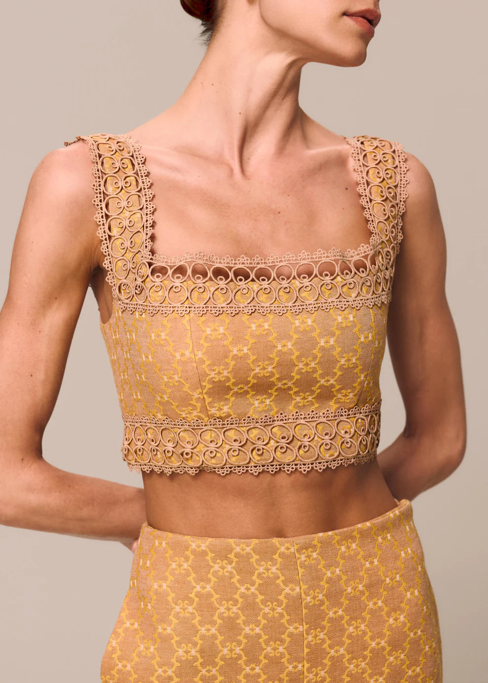 Yellow lace top worn by a model on a neutral background