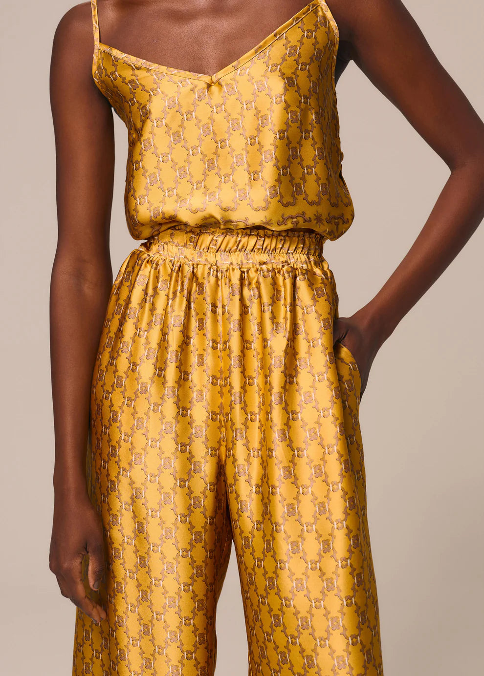 Yellow patterned top and pants set on a neutral background