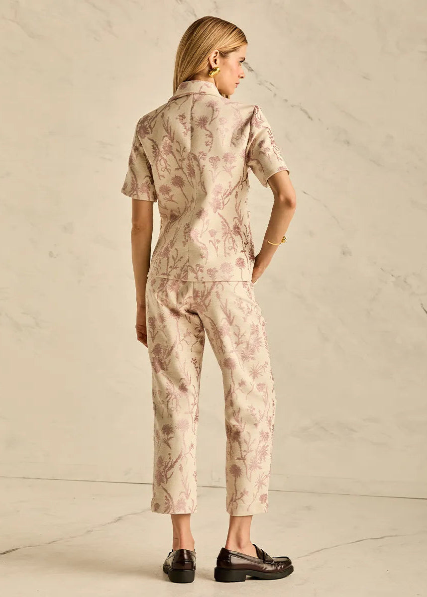 Woman wearing a floral outfit against a plain background