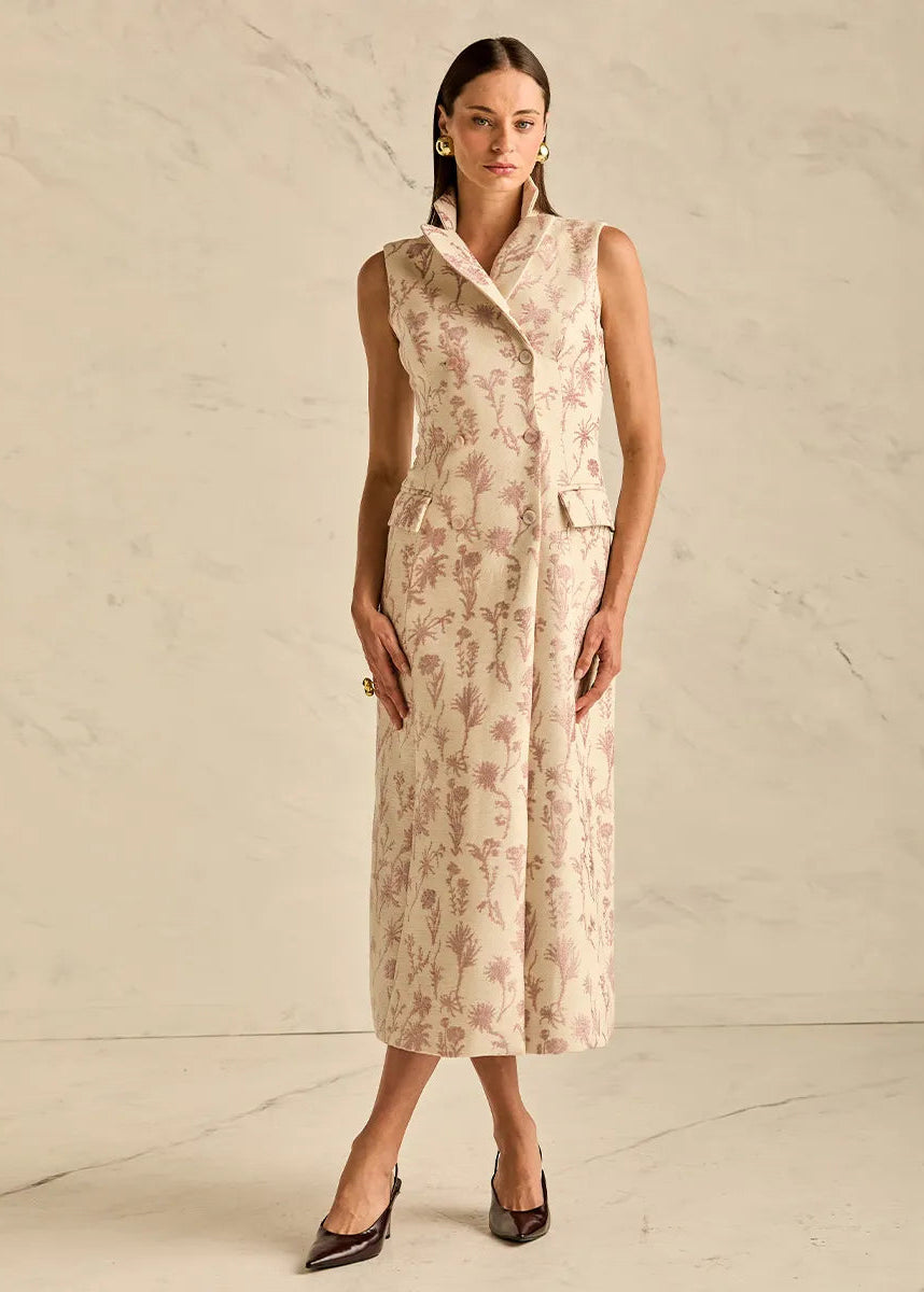 Woman wearing a sleeveless pink dress against a beige background