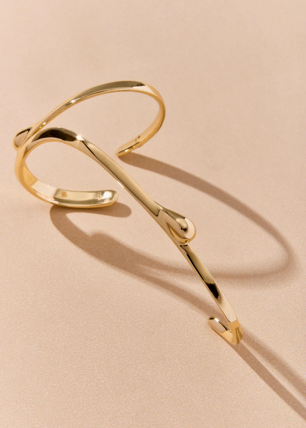 Gold bracelet on a beige background