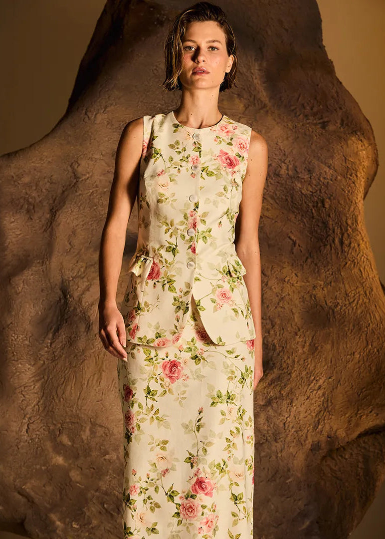 Woman wearing a pink sleeveless top and pants against a beige background