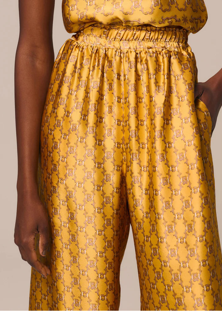 Yellow patterned top and pants set on a neutral background