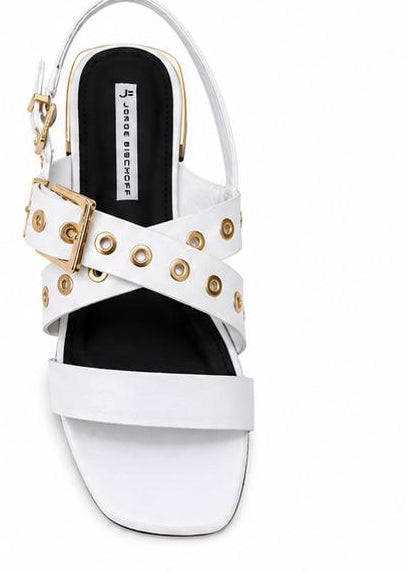 White and black sandals with embellishments on a white background